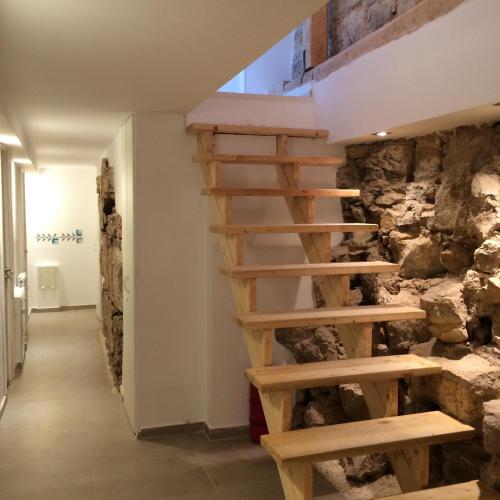 a wooden staircase in a room with a stone wall at Retro Hostel in Cluj-Napoca