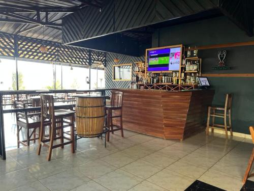 a restaurant with a bar with chairs and a flat screen tv at REBERO RESORT Ltd in Kigali