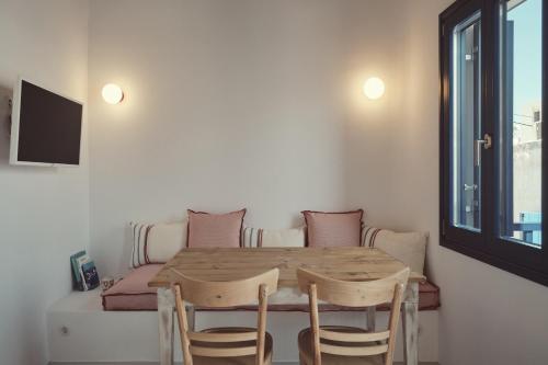 a table and chairs in a room with a window at Retreat Paros, Fisherman's House, The Hook Apartment in Parikia