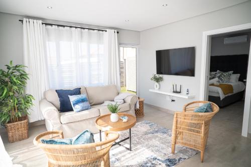a living room with a couch and a table at Cosy Private cottages 3 bedroom salt pool DSTV in Durban