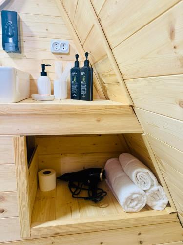 a small wooden cabinet with towels and toiletries in it at KolsayNestAframe in Saty