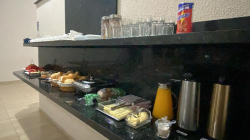 a counter with various food items on it at Hotel Ideal in Ribas do Rio Pardo
