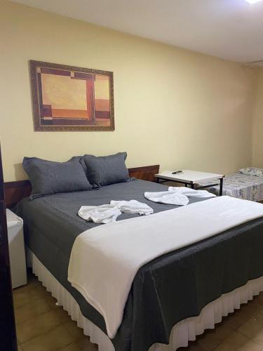 a bedroom with a bed with clothes on it at Hotel Vale Das Serras in Jacobina