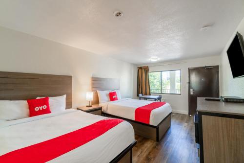 a hotel room with two beds and a flat screen tv at OYO Hotel Houston N Fm-1960 Champions TX in Houston