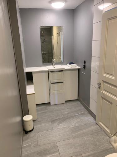 a bathroom with a sink and a mirror at Rymlig ljus lägenhet i lugnt område nära centrum in Borås
