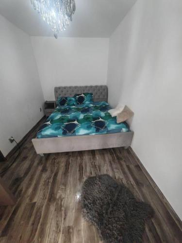 a bedroom with a bed with a blue comforter at Dorobanți Elite Living in Văleni