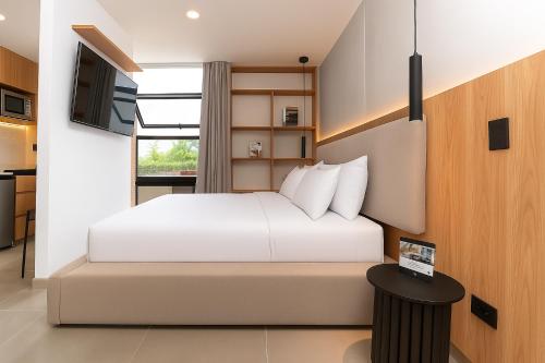 a bedroom with a white bed and a television at Metropolitan Living by HOUSY in Medellín