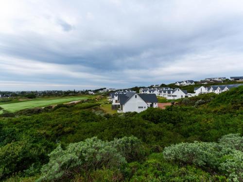 an aerial view of a subdivision of houses on a hill at St Francis Links - Elegant, Golfside & Coastal Apartment in St Francis Bay
