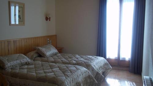 a bedroom with a bed and a large window at Hostal Pernalle in Erill la Vall