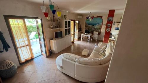 a living room with a white couch and a television at Villa Diamante in Diamante