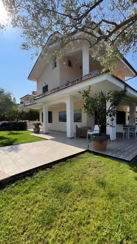 a large white house with a patio and grass at Villa Diamante in Diamante