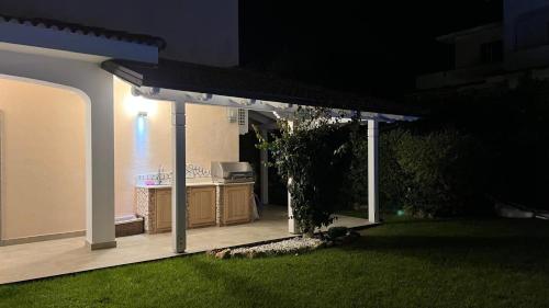 a lit up backyard at night with a pergola at Villa Diamante in Diamante
