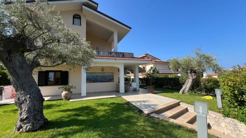 a house with a tree in the front yard at Villa Diamante in Diamante