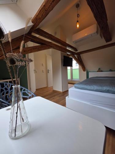 a vase with flowers on a table in a bedroom at Froschgass Apartments in Klingenberg am Main