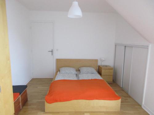 een slaapkamer met een bed met een oranje deken bij Gwenhadu in Paimpol