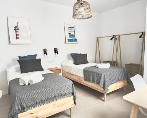 a bedroom with two beds and a pendant light at El Submarino Coastal Home in Santa Maria de Guia de Gran Canaria