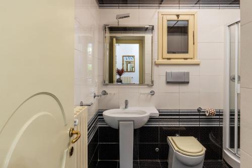 a bathroom with a sink and a toilet and a mirror at Trevi Garden Suite in Rome