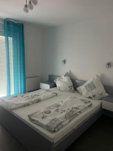 a bed with two pillows on it in a bedroom at Apartmani Lana in Rab