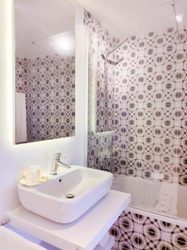 a white bathroom with a sink and a mirror at Casa da Tasquinha in Ponta Delgada