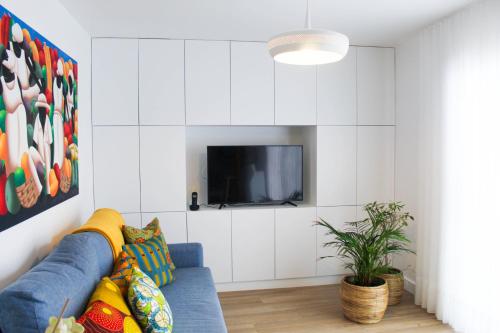 a living room with a blue couch and a tv at Casa da Tasquinha in Ponta Delgada