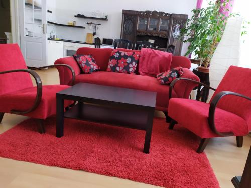 a living room with a red couch and two chairs at Penzion SIESTA in Příbor
