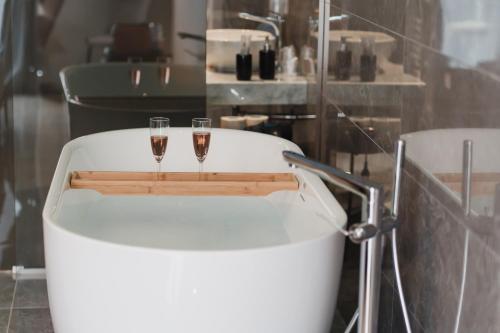 zwei Gläser Wein sitzen auf einer Badewanne in der Unterkunft La Residenza del Barone in Camerota