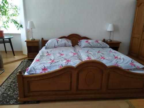 a bed with a wooden frame with flowers on it at Penzion SIESTA in Příbor