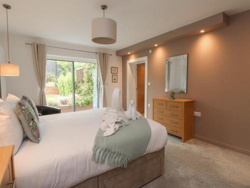 a bedroom with a bed with a dresser and a television at Môr Glas in Conwy