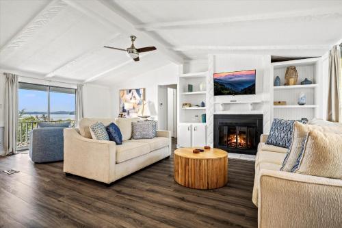 a living room with two couches and a fireplace at Lakefront Mountain Oasis in Dandridge