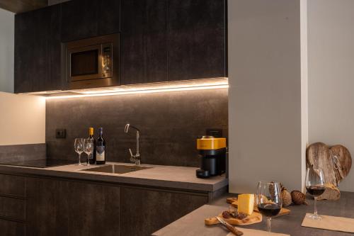 a kitchen with a sink and a counter with wine glasses at Lillaz Home - Apartments in Cogne