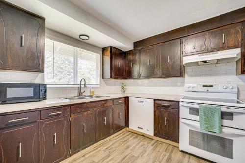 a kitchen with wooden cabinets and white appliances at Cozy Apt with Private Deck, 2 Mi to Toyota Center! in Kennewick