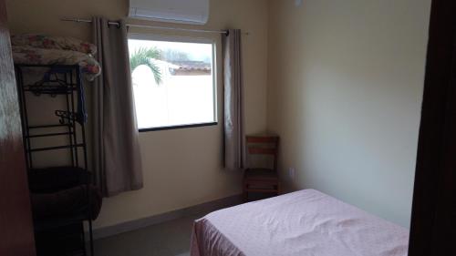 マリカーにあるRecanto do gauchoのベッドと窓のある小さな寝室