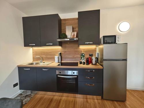 a kitchen with black cabinets and a stainless steel refrigerator at Trilo Orologio in Clusone