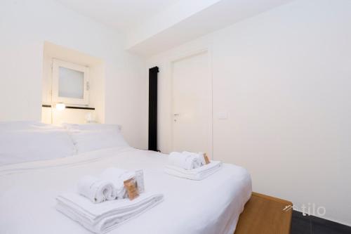 a white bedroom with two beds with towels on them at Bocadasse Beach| Wifi| Boho Luxury By Tilo in Genova