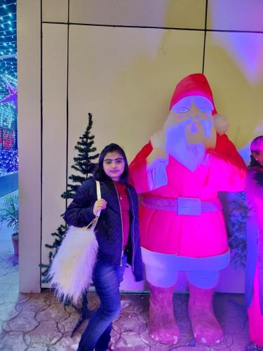 a woman standing next to a giant santa claus at Raheemia Home Stay in Srinagar