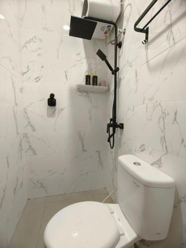 a white bathroom with a toilet and a shower at Quattrick Villa in Tlekung