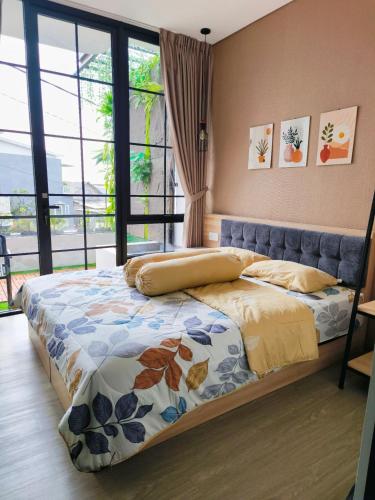 a bedroom with a bed and a large window at Quattrick Villa in Tlekung