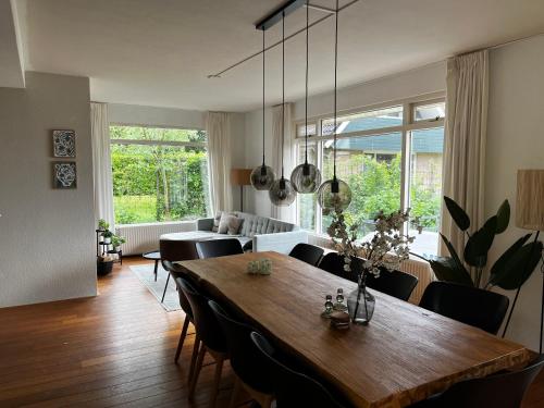 a dining room with a wooden table and chairs at Vakantiehuis Lytse Mar in Idskenhuizen