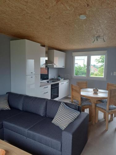 a living room with a blue couch and a table at Gîtes L'Evasion Thudinienne in Thuin