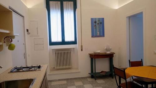 a kitchen with a table and a window and a table at La Radiolina in Lecce
