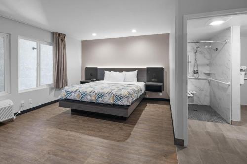 a bedroom with a large bed and a shower at Motel 6-La Mesa, CA in San Diego