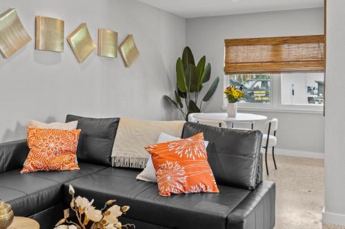 a black couch with orange pillows in a living room at Captiva Beach Resort (open private beach access) in Sarasota