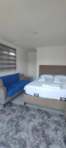 a bedroom with a large bed and a couch at Neşe &Alp Apart Pansiyon in Demre