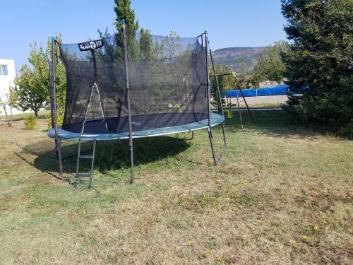 a trampoline in a yard with a net at Villa Almas with swimming pool, tennis court, sauna, gym, grill house in Neorić