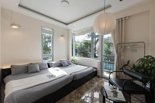 a bedroom with a large bed and windows at LOMO house in Khu Chi Lăng