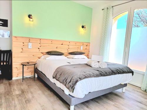 a bedroom with a large bed with a wooden headboard at Domaine de la Mautanne in Sainte-Tulle
