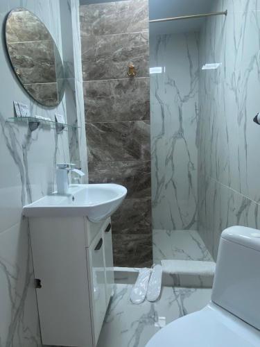 a white bathroom with a sink and a mirror at Villa de Nord in Soroca