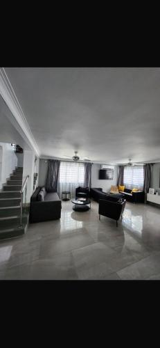 a large living room with couches and a staircase at Casalabeba in Santo Domingo