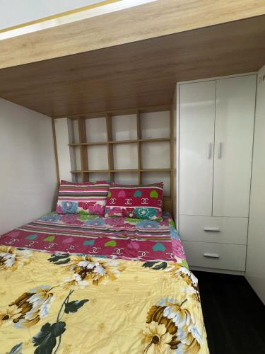 a bedroom with a bed with a flowery comforter at The Hidden Hogwarts - Nearly Bui Vien Walking street in Ho Chi Minh City