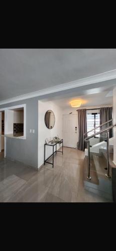 a living room with a staircase and a table at Casalabeba in Santo Domingo